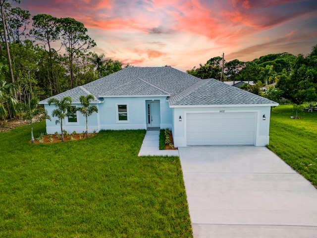 view of front facade with a garage and a lawn