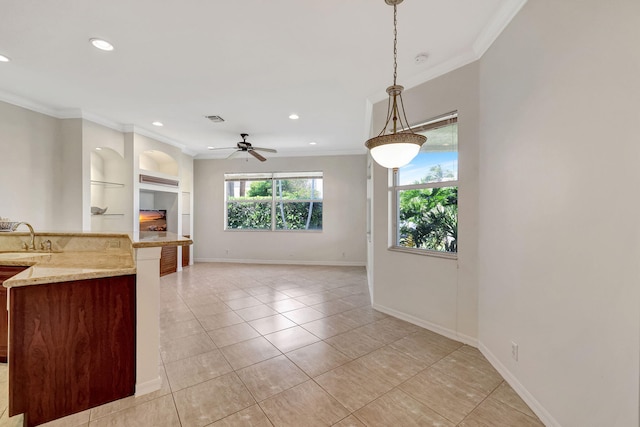 kitchen featuring pendant lighting, ceiling fan, light tile floors, and light stone counters