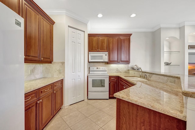 kitchen featuring white appliances, tasteful backsplash, light stone countertops, and sink