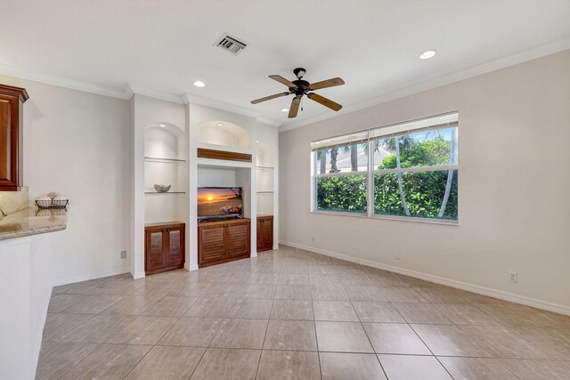 unfurnished living room with built in features, ornamental molding, ceiling fan, and light tile floors