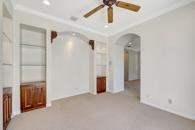 empty room with crown molding, light colored carpet, and ceiling fan