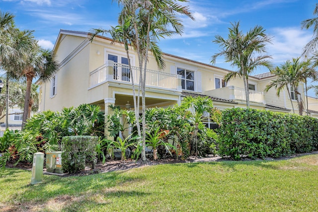 view of front facade featuring a front yard and a balcony