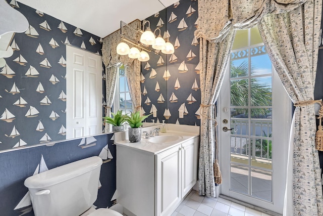 bathroom featuring a wealth of natural light, vanity, toilet, and tile flooring