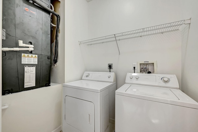 laundry room with electric dryer hookup, heating utilities, hookup for a washing machine, and washing machine and clothes dryer