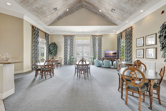 carpeted dining space with high vaulted ceiling and ornamental molding