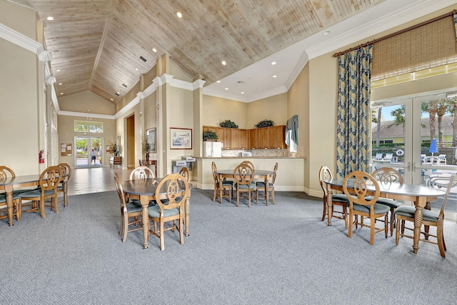 carpeted dining room featuring french doors, ornamental molding, high vaulted ceiling, and wooden ceiling