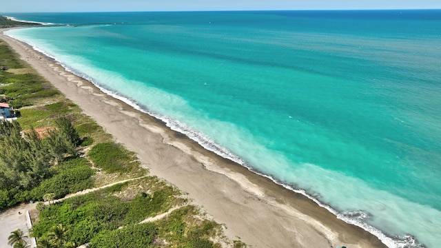 drone / aerial view featuring a water view and a view of the beach