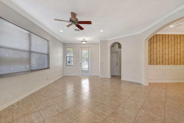 tiled spare room with ornamental molding and ceiling fan