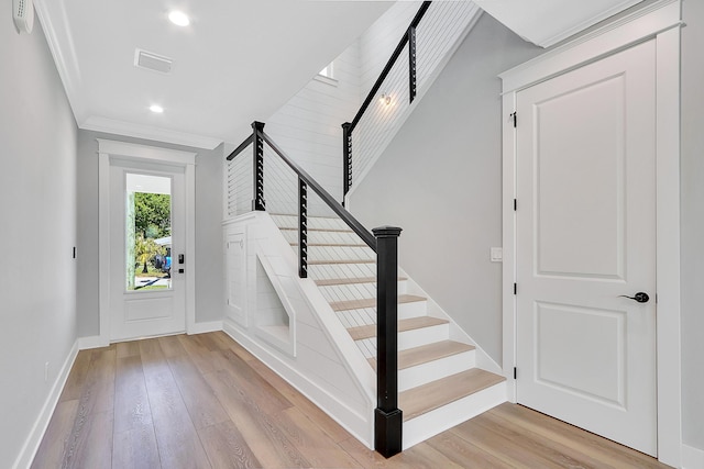 foyer entrance featuring light hardwood / wood-style flooring and ornamental molding