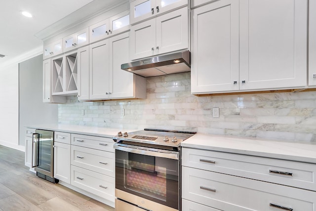 kitchen featuring decorative backsplash, light wood-type flooring, white cabinets, wine cooler, and stainless steel range with electric cooktop