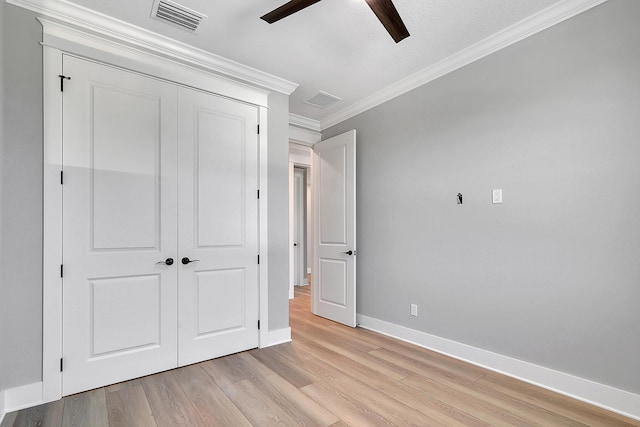 unfurnished bedroom with ceiling fan, a closet, light hardwood / wood-style flooring, and ornamental molding