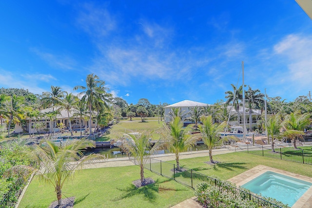 view of pool with a water view and a lawn