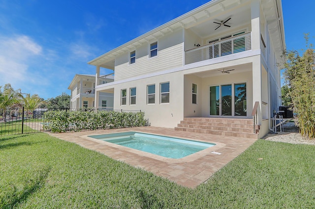 back of house with ceiling fan, a yard, and a balcony