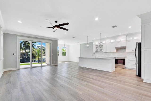 kitchen with white cabinets, ceiling fan, an island with sink, appliances with stainless steel finishes, and decorative light fixtures