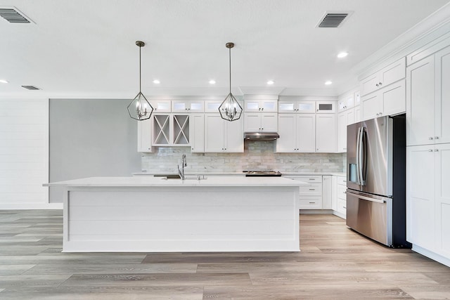 kitchen featuring appliances with stainless steel finishes, sink, pendant lighting, a center island with sink, and white cabinets