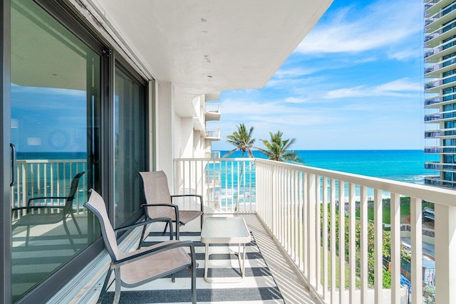 balcony featuring a beach view and a water view