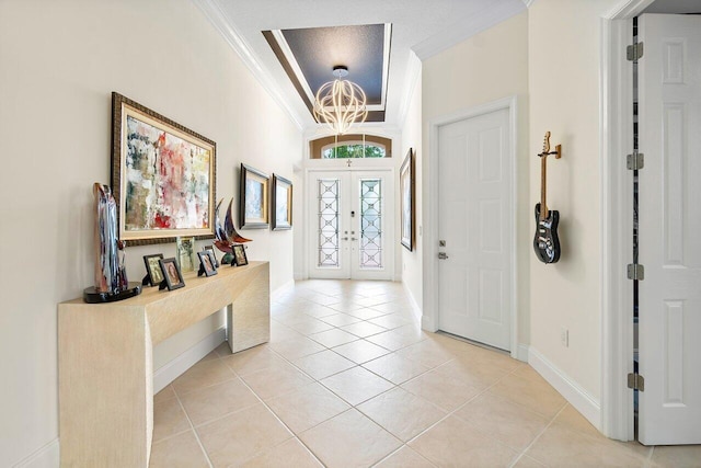 tiled foyer with a chandelier, ornamental molding, and french doors