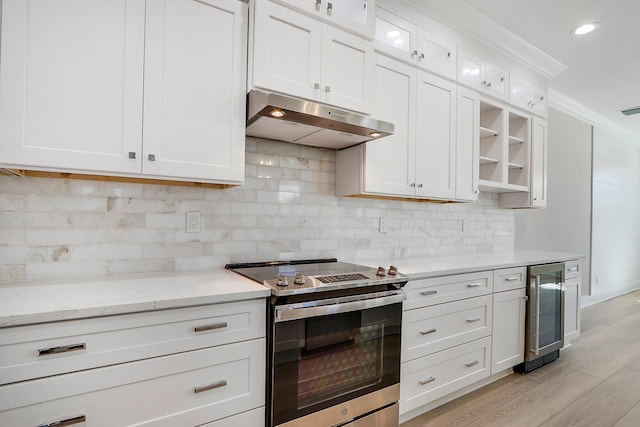 kitchen with light hardwood / wood-style floors, white cabinetry, stainless steel electric range oven, and wine cooler