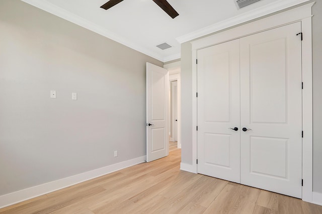 unfurnished bedroom featuring ceiling fan, light hardwood / wood-style floors, ornamental molding, and a closet