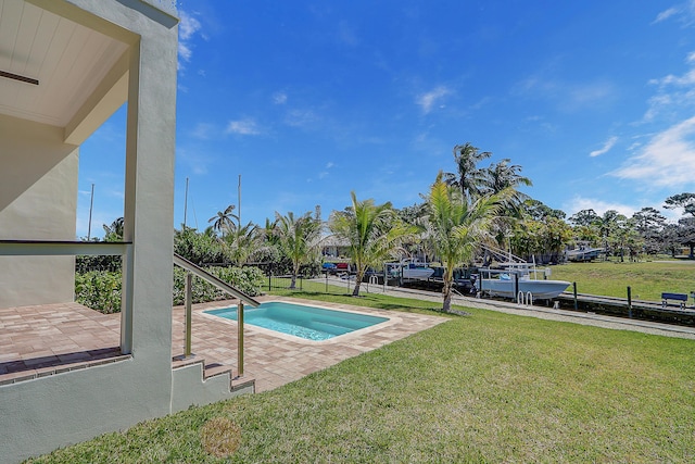 view of pool with a patio and a lawn