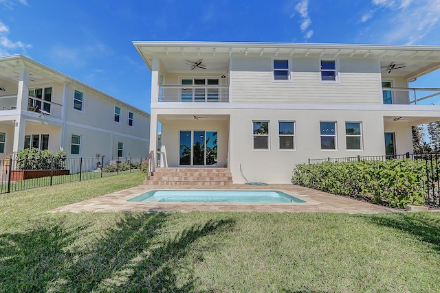 rear view of property featuring a lawn, ceiling fan, and a balcony