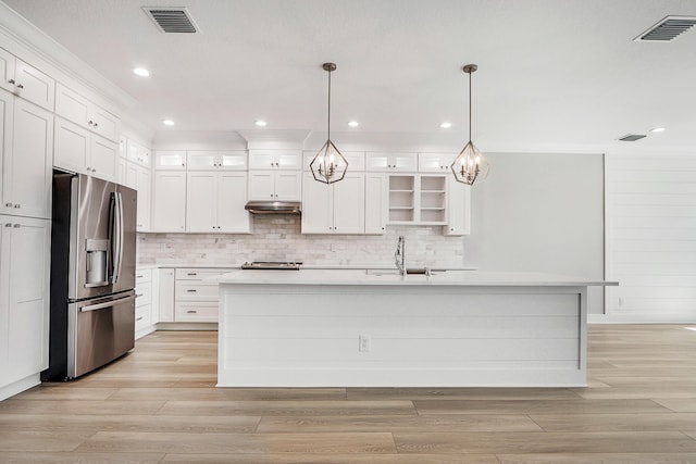 kitchen featuring stainless steel fridge, white cabinetry, a kitchen island with sink, and pendant lighting