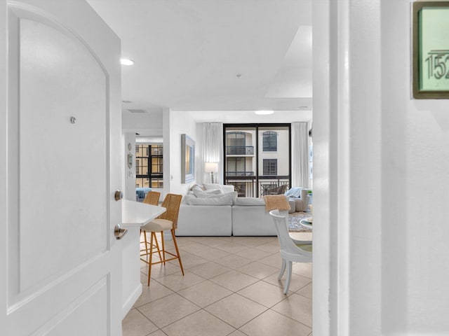 living room featuring arched walkways and light tile patterned flooring