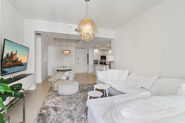 living room with light tile floors and an inviting chandelier