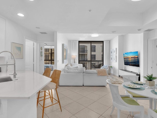 living area featuring light tile patterned flooring, visible vents, and recessed lighting