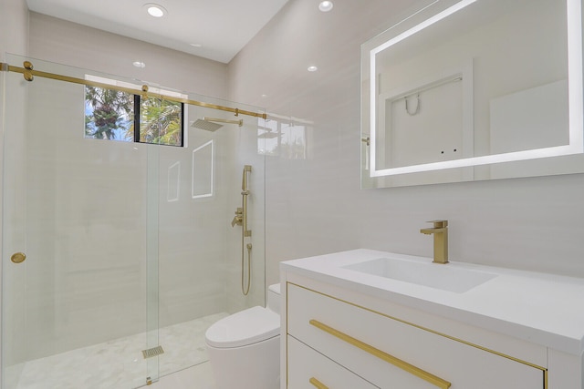 bathroom featuring a shower with door, toilet, and large vanity