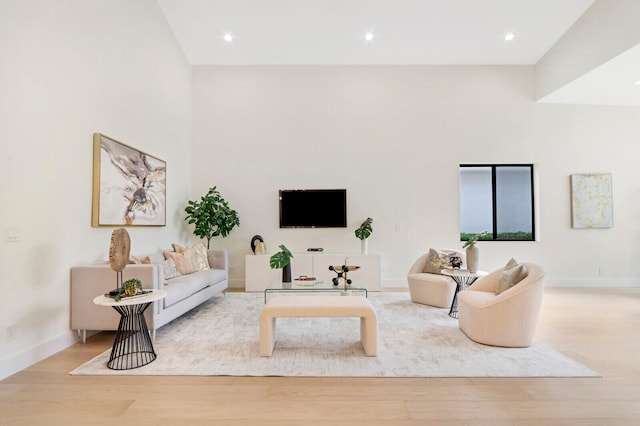 living room featuring light hardwood / wood-style flooring and high vaulted ceiling