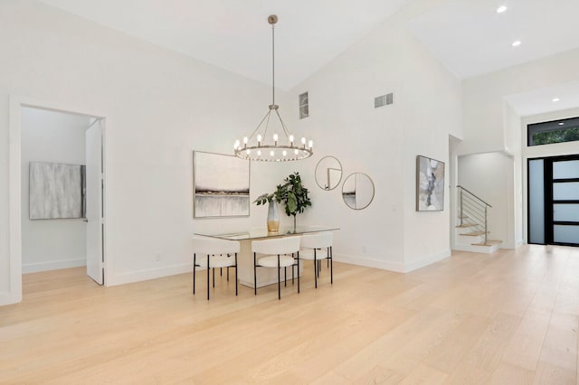 dining room featuring light hardwood / wood-style floors, high vaulted ceiling, and a notable chandelier