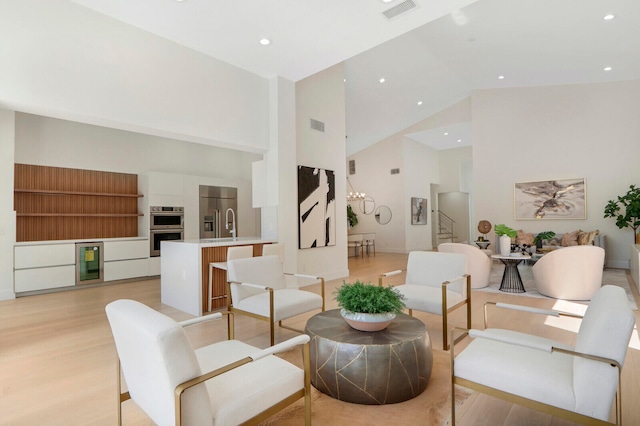 interior space featuring high vaulted ceiling, wine cooler, and light hardwood / wood-style floors