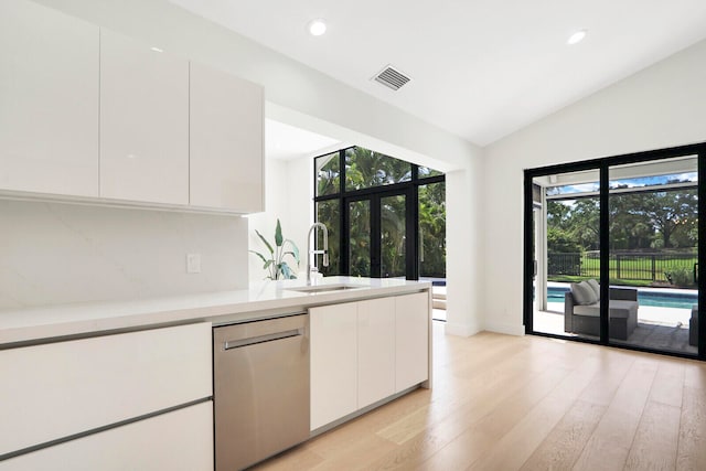 kitchen featuring sink, white cabinetry, light wood-type flooring, and stainless steel dishwasher