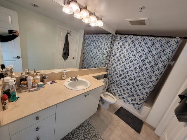 bathroom featuring toilet, tile floors, and vanity