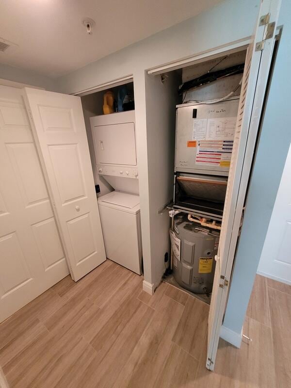 utility room with stacked washer / dryer