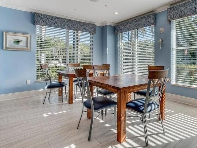 dining area with light hardwood / wood-style flooring and crown molding