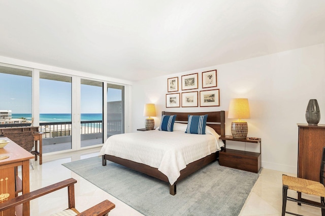 tiled bedroom featuring expansive windows, access to exterior, and a water view