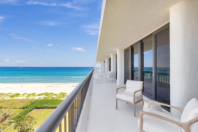 balcony featuring a beach view and a water view