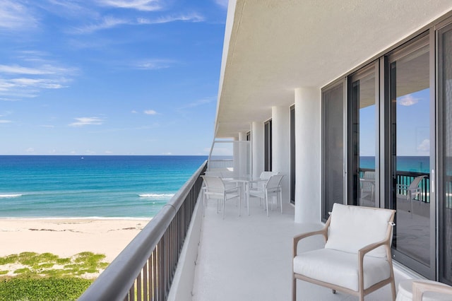 balcony featuring a water view and a view of the beach