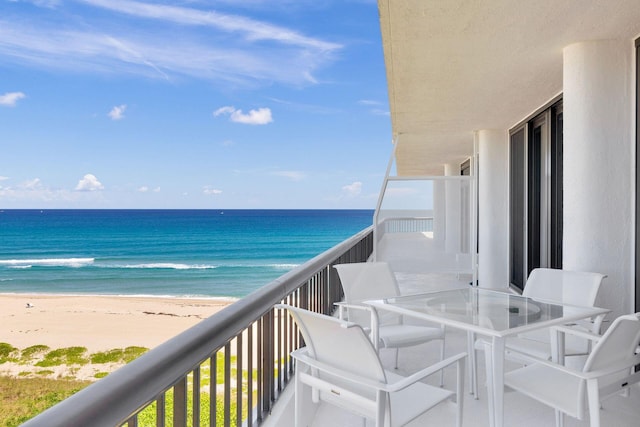 balcony featuring a water view and a beach view