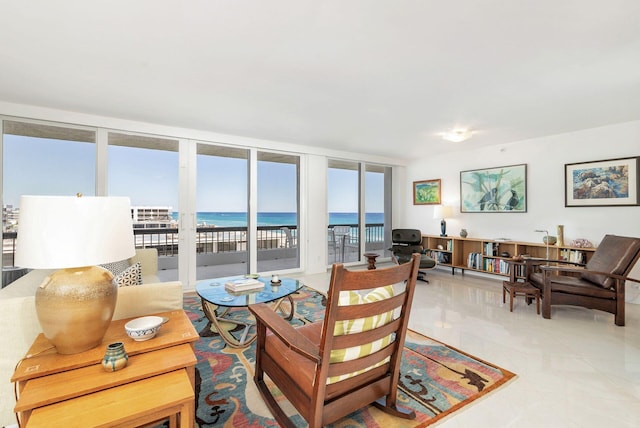 living room featuring a water view, light tile flooring, and expansive windows