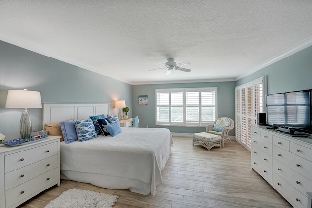 bedroom with ornamental molding, ceiling fan, a textured ceiling, and light wood-type flooring