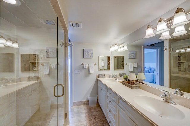 bathroom with a shower with door, vanity with extensive cabinet space, and double sink