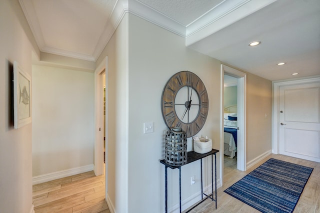 corridor with light hardwood / wood-style floors and crown molding