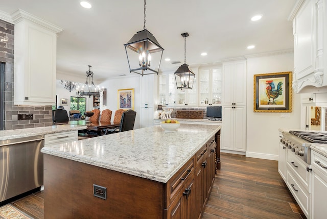 kitchen with a kitchen island, decorative light fixtures, white cabinets, and appliances with stainless steel finishes