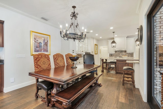 dining room featuring crown molding, dark hardwood / wood-style floors, and an inviting chandelier