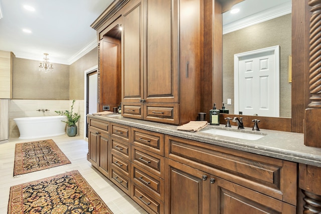 bathroom with crown molding, vanity, an inviting chandelier, and a tub