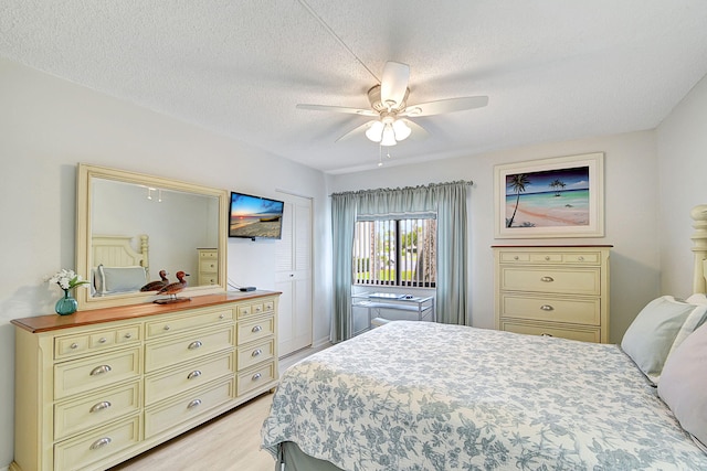 bedroom featuring a textured ceiling, ceiling fan, and light hardwood / wood-style floors