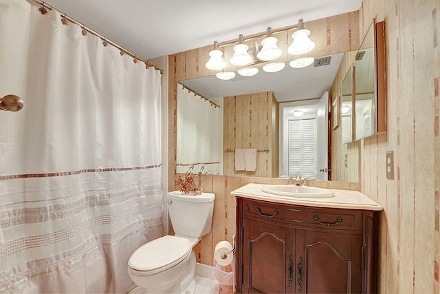 bathroom featuring wooden walls, toilet, tile floors, and vanity